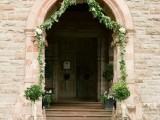 decorate the entrance with greenery garlands and potted greenery and put candles on the steps