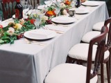 a gorgeous Italian wedding tablescape with greenery, bold blooms and grapes as a table runner is amazing