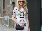 a white dress with black touches and bold floral embroidery styled wiht a black bag and shoes for a bold and chic spring or summer wedding guest look