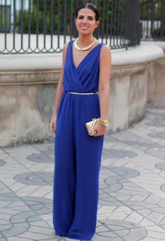 An electric blue jumpsuit with a V neckline and palazzo pants, with a polished belt, a neckline and a mini clutch for a formal wedding guest look