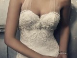 a creative lace embellished sheath wedding dress with a halter neckline is a chic and refined idea