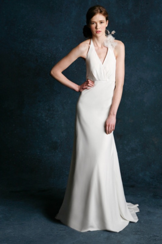 A plain sheath wedding dress with a halter neckline and a feather clip to make it stand out