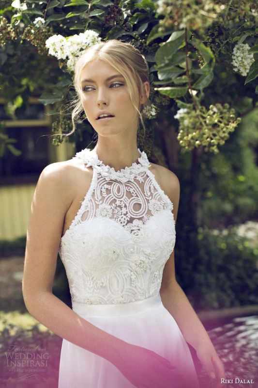 An A line wedding dress with a lace embellished bodice with a halter neckline, a plain skirt for a modern glam bride