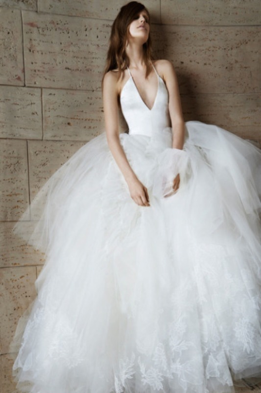 a halter neckline princess style wedding dress with a plain bodice and a full skirt of layers is a unique combo