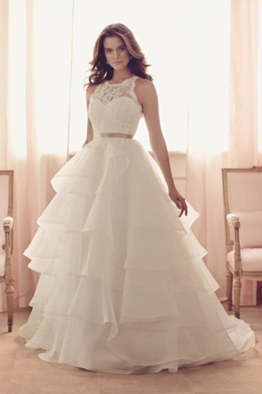 A sleeveless A line wedding dress with a layered skirt, a lace bodice and a silver belt