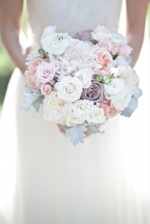 a pastel wedding bouquet of blush, lilac and white blooms and pale greenery for a spring or summer wedding