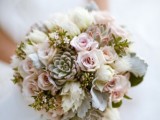 a pastel wedding bouquet of neutral and blush blooms and some pale greenery and succulents