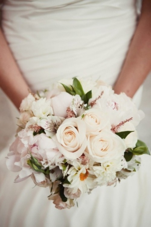 a pretty pastel wedding bouquet of blush and white blooms and some greenery plus textural elements