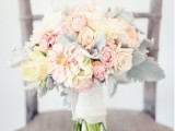 a pastel wedding bouquet of blush, neutral and peachy blooms and pale greenery