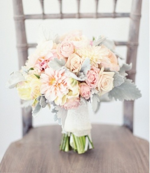 a pastel wedding bouquet of blush, neutral and peachy blooms and pale greenery