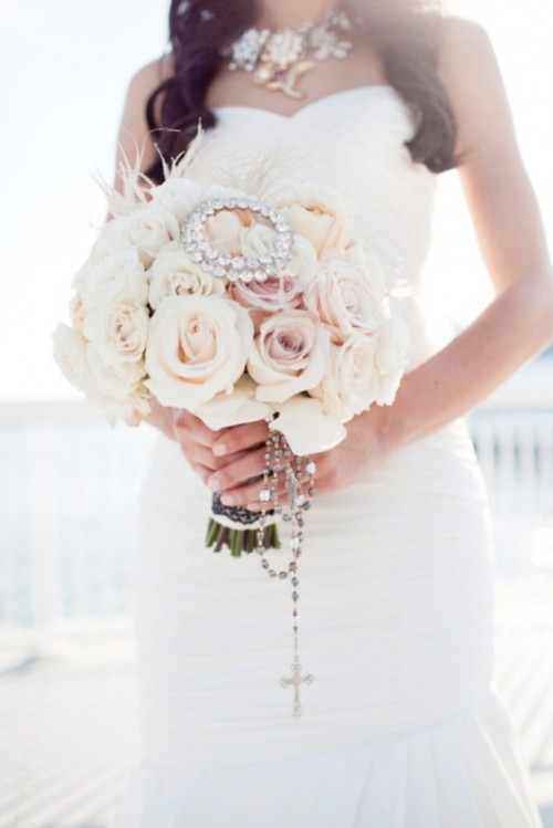 a glam neutral and blush rose wedding bouquet with a rhinestone detail and rosary hanging down