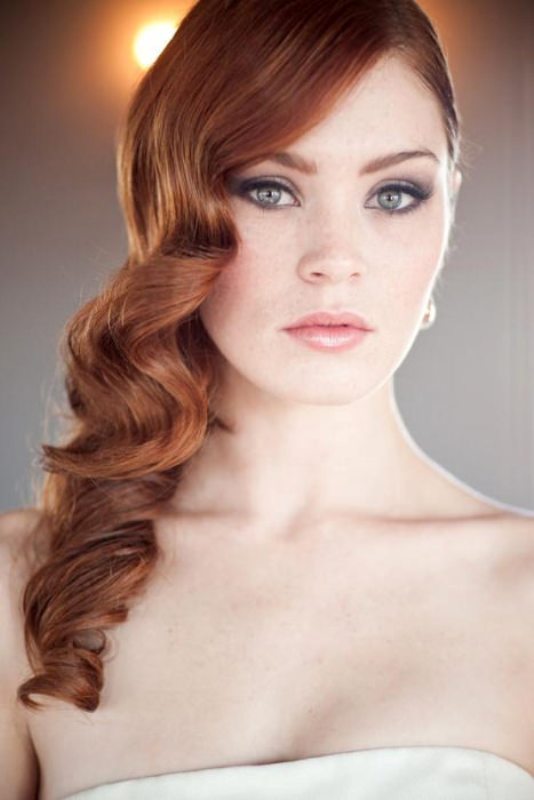 Long amber hair in vintage curls looks very elegant and such a structure highlights the color of hair