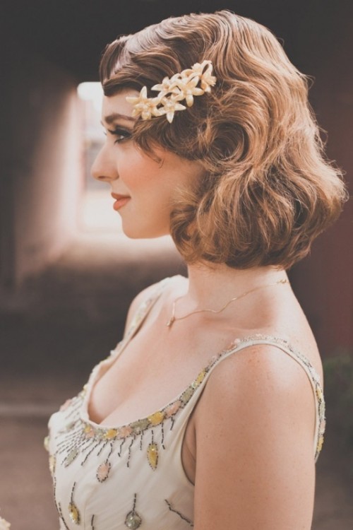 vintage Hollywood waves on short hair looks very chic and elegant and a flower hairpiece brings a feminine feel