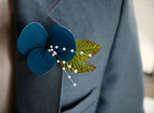 a pretty modern boutonniere of a teal fabric flower and leaves plus beads is a catchy idea that you can DIY
