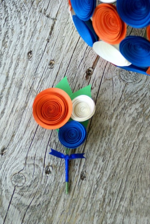 a bold and unique ribbon boutonniere shaped as a white, orange and electric blue flower with a bow is a cool solution to rock