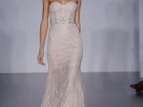 a blush strapless wedding dress with a corset bodice, a semi sheer skirt with a train and an embellished sash