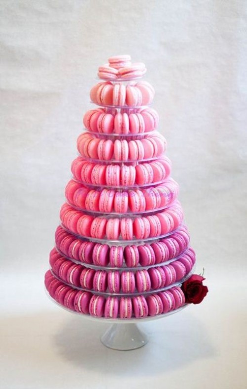 a pink ombre macaron tower on a clear stand is a bold and cool idea for a modern wedding, no one wants a cake when one can have a couple of delicious macarons