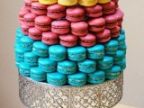 a refined metal stand with lots of colorful macarons stacked is a lovely idea for your wedding that features lots of color