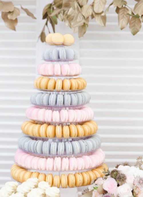 a pretty pastel pink, blue and yellow macaron tower with a clear stand is a gorgeous idea for a modern spring or summer wedding