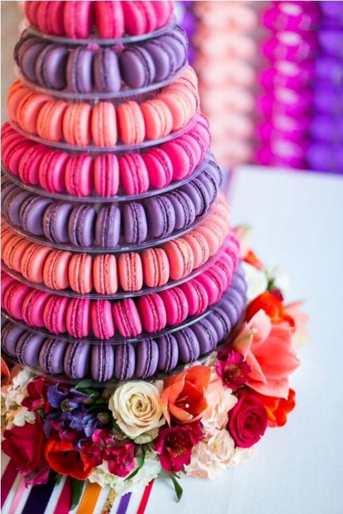 a super colorful macaron tower that includes puple, hot pink and orange sweets is a gorgeous solution for a super bold wedding