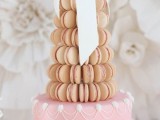 a pastel wedding cake with macarons – a tan macaron tower plus a white sugar bow, a pink cake with white sugar detailing for a super glam wedding