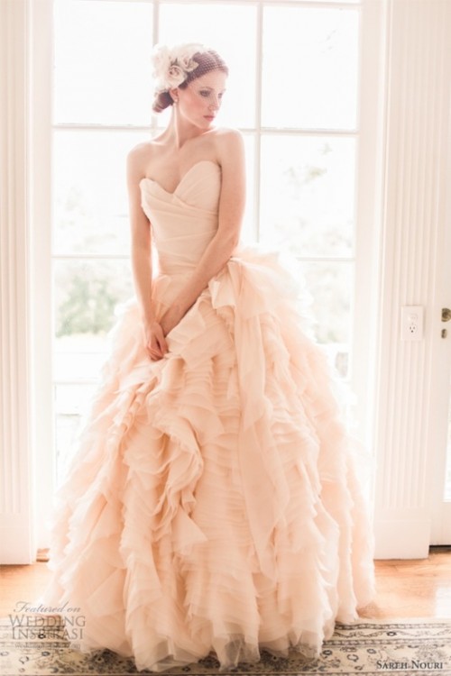 a strapless blush wedding ballgown with a draped bodice and a layered skirt plus a matching headpiece for a vintage-inspired look