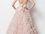 a blush strapless wedding dress with a draped bodice, floral applique skirt, a train and a blush bow to match a girlish look