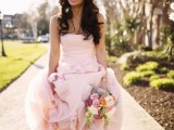 a pastel pink strapless wedding dress with a draped bodice and a tiered skirt, matching peep toe wedding shoes to create a feminine look