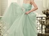 a pastel green strapless wedding ballgown with a draped bodice and a layered skirt plus an embellished sash is amazing