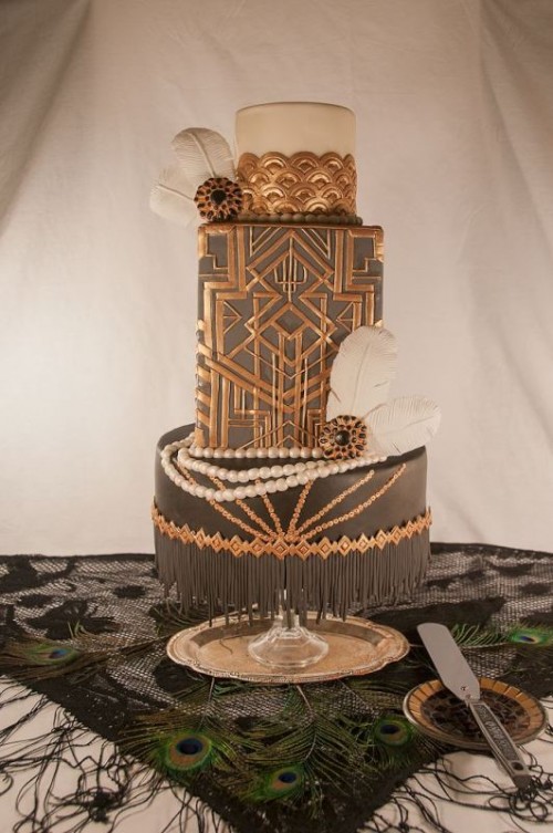 a super glam gold, black and white wedding cake decorated with edible feathers, pearls and geometric art deco detailing