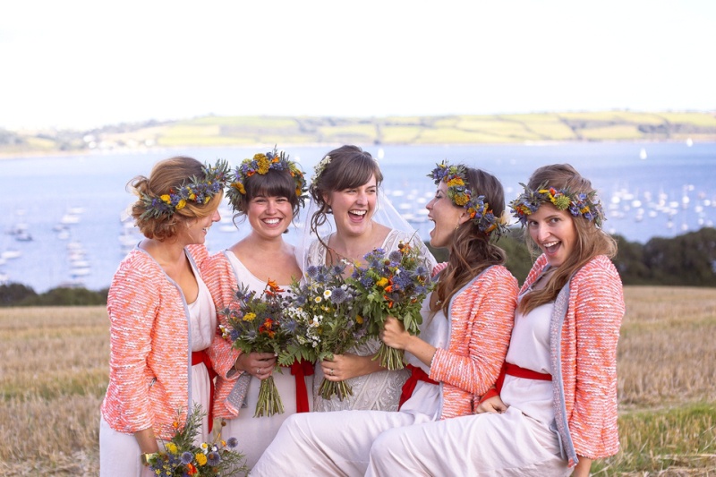 coral pink cardigans add color to the bridesmaid looks, match red sashes and finish off their country outfits
