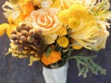 a sunny yellow wedding bouquet with roses, dahlias, billy balls, pale leaves is a catchy idea for a spring or summer bride
