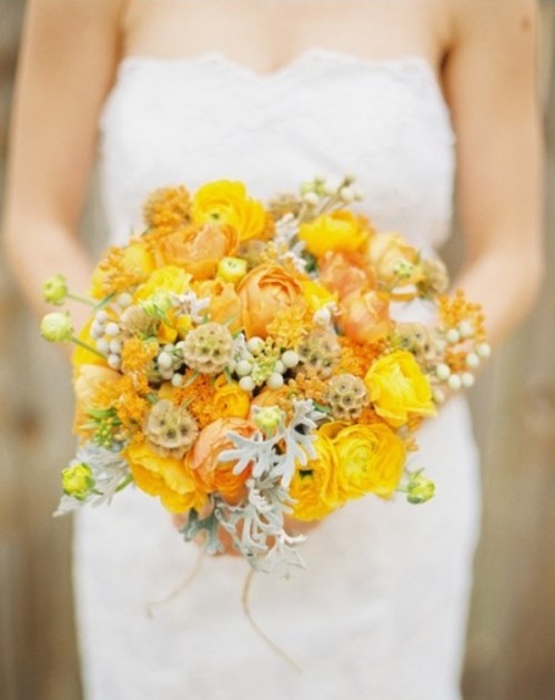 a yellow wedding bouquet of ranunculus, pale millet and seed pods is a catchy and bright idea for a fall wedding