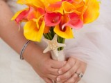 a bright orchid wedding bouquet of yellow and pink blooms with a starfish is a bold solution for a tropical beach wedding