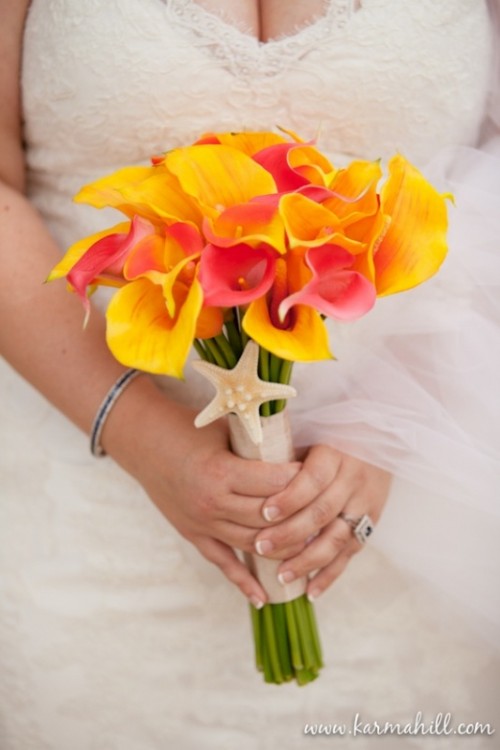 a bright orchid wedding bouquet of yellow and pink blooms with a starfish is a bold solution for a tropical beach wedding