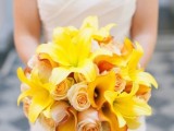 a bright yellow wedding bouquet of yellow lilies, blush roses and peachy orchids is a bold and chic idea for a tropical bride
