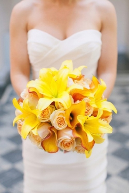 a bright yellow wedding bouquet of yellow lilies, blush roses and peachy orchids is a bold and chic idea for a tropical bride