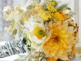 a yellow and white wedding bouquet of dahlias, ranunculus, roses, greenery and some white flowers is a stylish idea