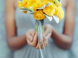a yellow ranunculus and pale leaf wedding bouquet is a catchy and contrasting idea, suitable not only for brides but also for bridesmaids