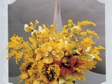 a lush fall wedding bouquet of mimosas, yellow and burgundy orchids, green ones and yellow ribbons is fantastic