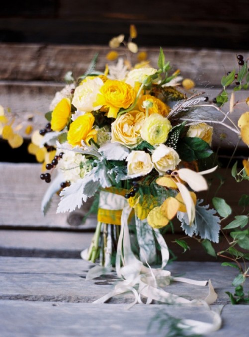 a chic yellow wedding bouquet of peony roses, pale millet, berries is a bold and cool idea for a summer or fall wedding