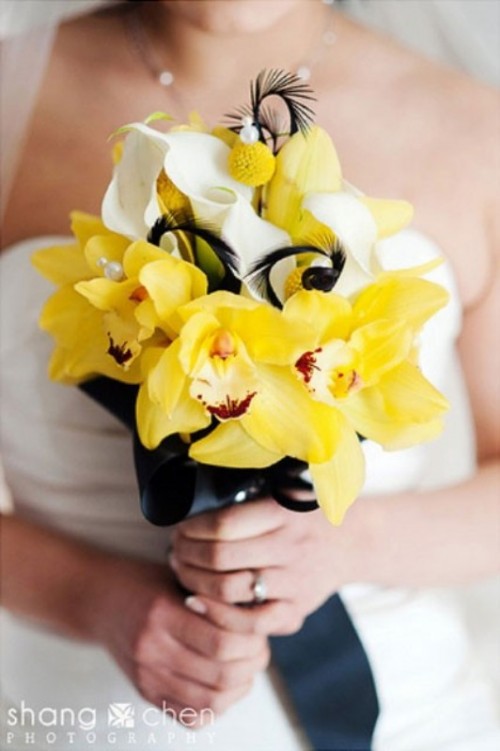 a bold wedding bouquet of yellow orchids, white callas, billy balls and black feathers plus a black wrap is a chic and whimsy idea