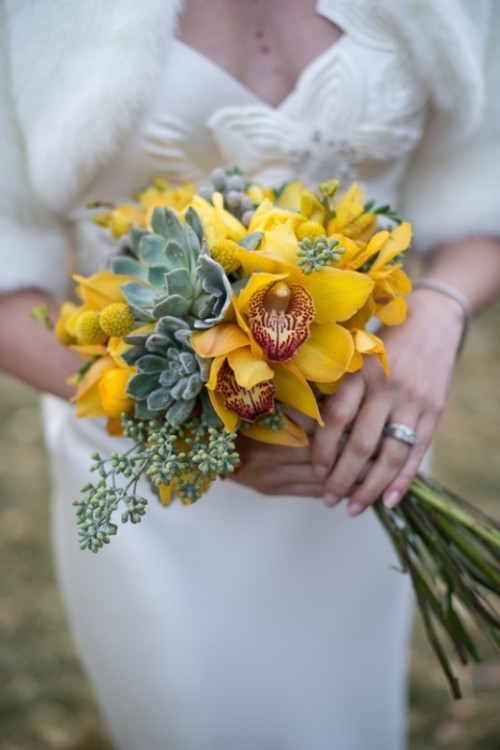 a bright wedding bouquet of yellow orchids, billy balls, succulents plus seeded eucalyptus is a statement with plenty of color and trendy succulents