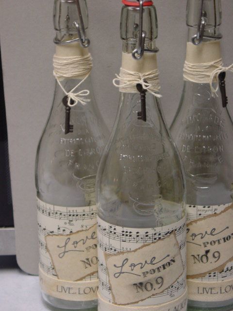 vintage water bottles wrapped with note paper, with tags and vintage keys are served as Love Potion