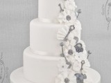 a white and silver wedding cake decorated with sugar ruffles, vintage keys and locks and with bird toppers is a lovely and cool idea for a wedding