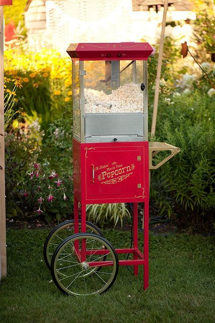 a red vintage-inspired popcorn automate on wheels is a fun idea to give a cool vintage touch to your wedding
