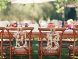 wine cork monograms hanging on wedding chairs are a cool idea to personalize the chairs instead of usual signs