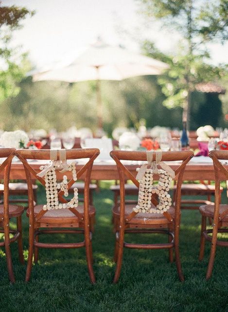 wine cork monograms hanging on wedding chairs are a cool idea to personalize the chairs instead of usual signs
