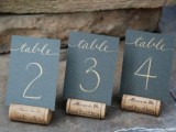 chalkboard table numbers placed on wine corks is a cool and simple idea to go for