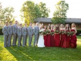 groomsmen wearing grey suits with red ties and bridesmaids wearing red maxi dresses